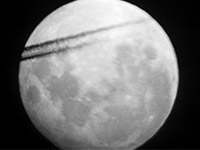 jet plane contrail across the face of the moon